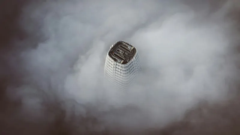 White concrete building surrounded by clouds by Denys Nevozhai